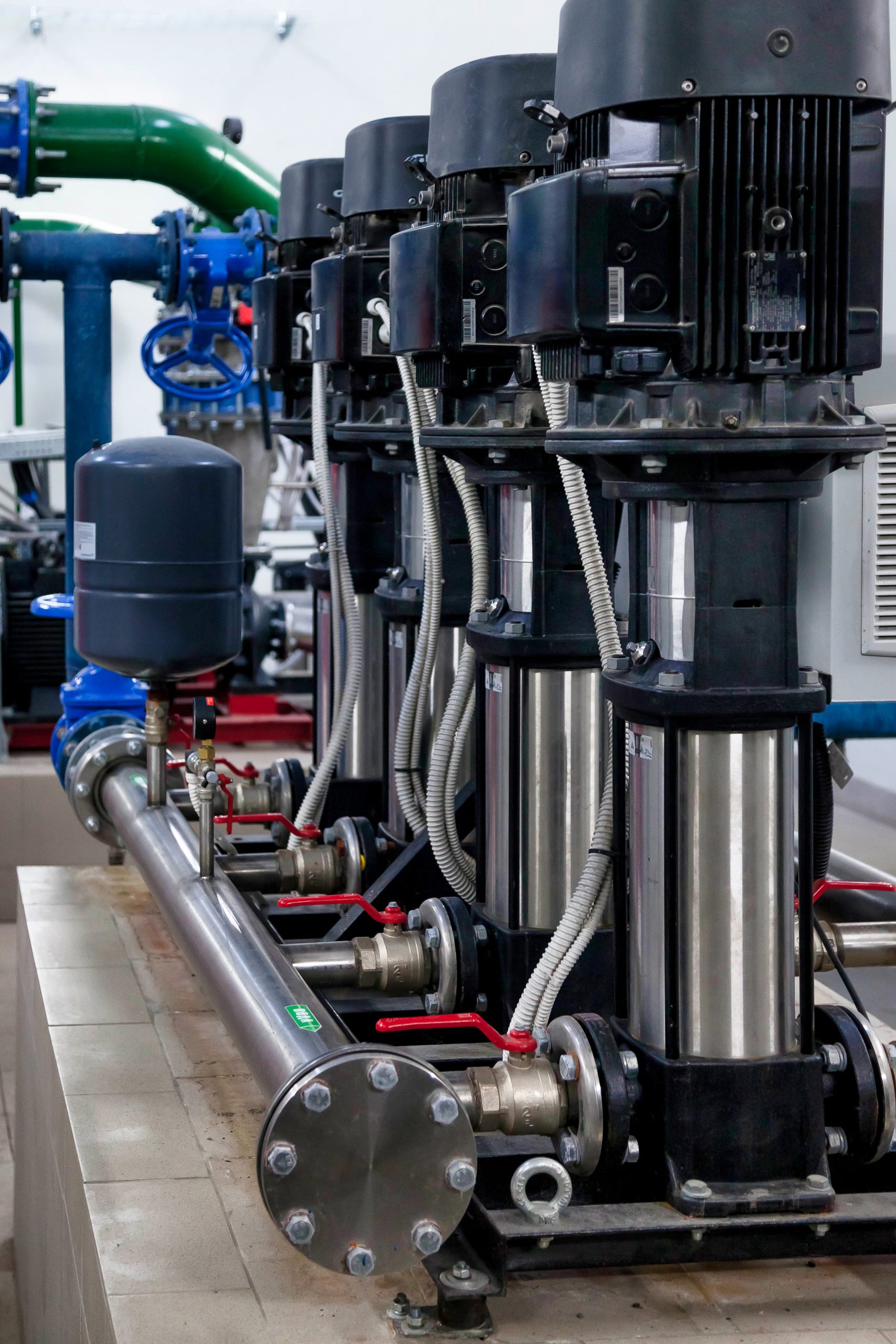 Industrial interior of water pump, valves, pressure gauges, motors inside engine room. Valve and pumps in an industrial room. Urban modern powerful pipelines and pumps, automatic control systems